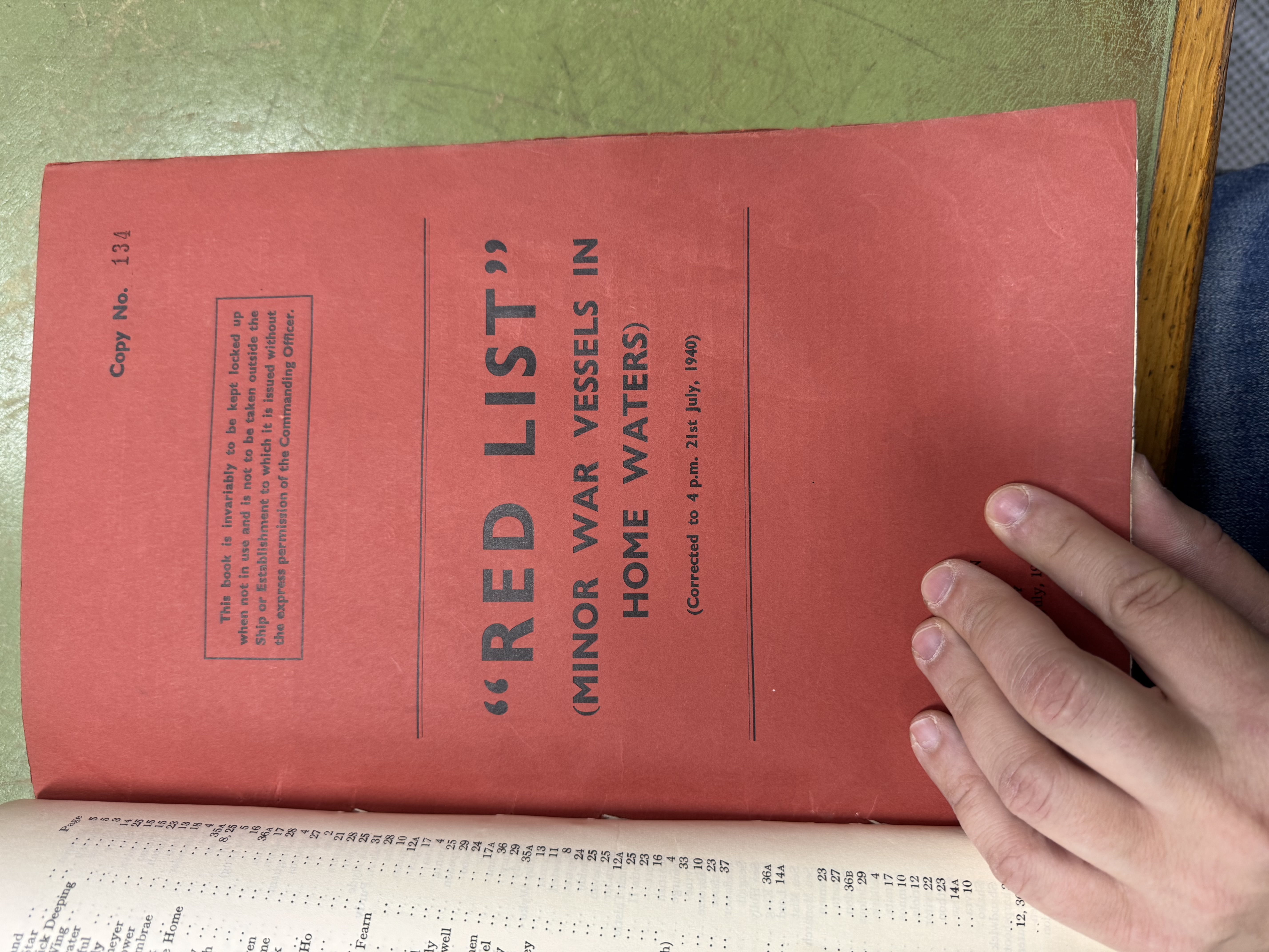 Archivist examining wartime maritime documents.